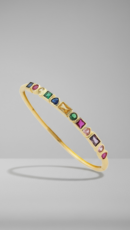 Gold bracelet with colorful gemstones on a gray background